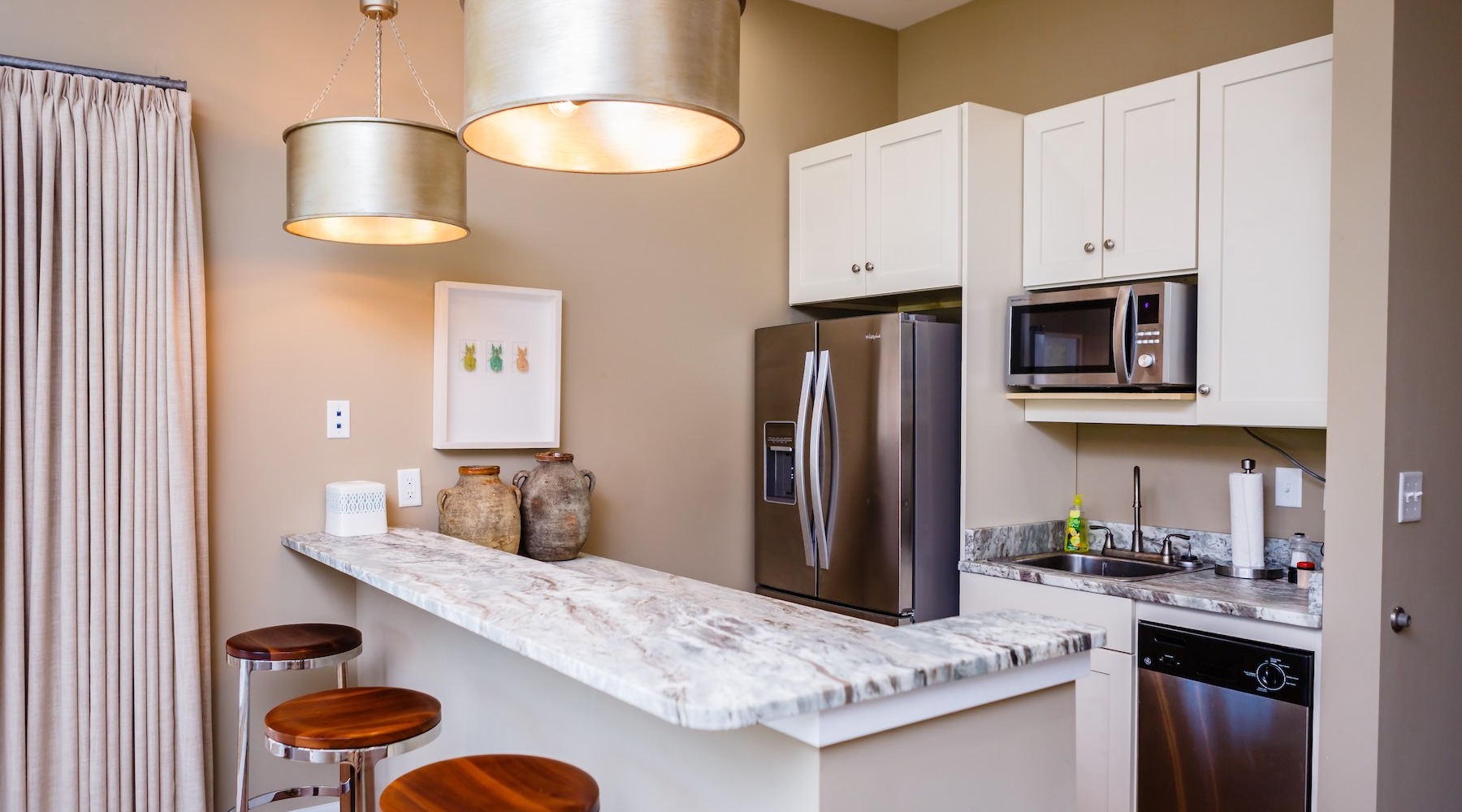 a kitchen with white cabinets and chairs